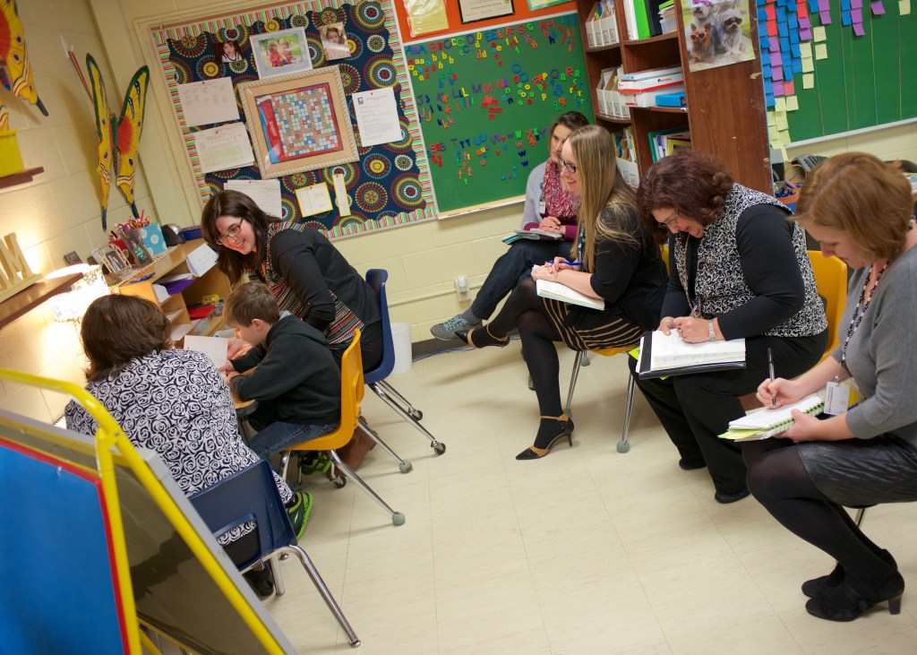 A group of four participate in a Reading Recovery cluster visit in the Title I room at Lynch Elementary. Top to bottom: Kasie Allen, Cortney Brendel, Cheryl Smith and Karen Allmen. 